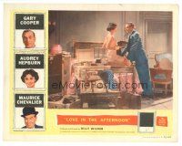 7z570 LOVE IN THE AFTERNOON LC '57 Audrey Hepburn sitting on packed suitcase, Gary Cooper!