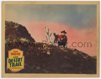 9y395 DESERT TRAIL LC R1939 great far shot of John Wayne crouching with gun by his horse!