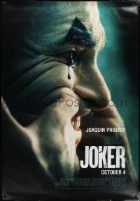 1g0082 JOKER DS bus stop 2019 close-up image of clown Joaquin Phoenix putting on a happy face!