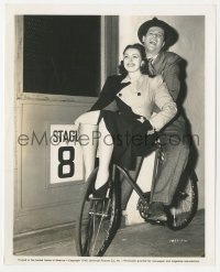 2b1859 ROBERT CUMMINGS/NANCY KELLY 8x10 still 1940 clowning around on bicycle on the studio lot!