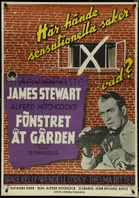 5k0135 REAR WINDOW Swedish 1955 Alfred Hitchcock, c/u of voyeur Jimmy Stewart with binoculars!