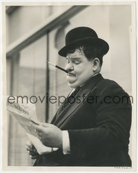 7b1452 OLIVER HARDY 8x10 still 1938 smoking cigarette in holder & reading up on vacation pointers!